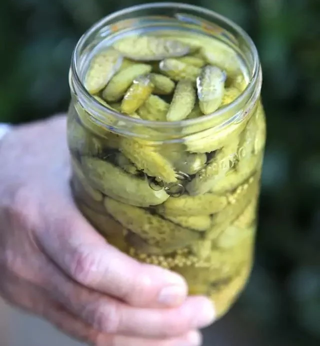 Bocal de cornichons maison au vinaigre prêts à être dégustés.