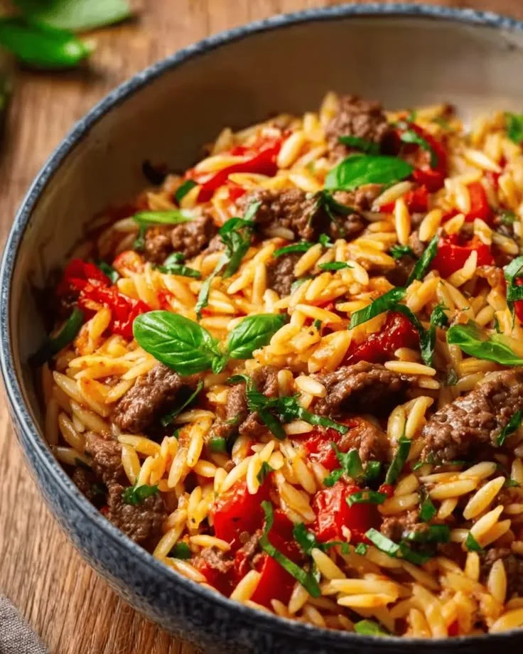 Bol d'orzo au bœuf haché servi avec des herbes fraiches
