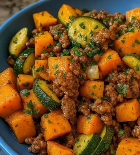 Patates douces sautées avec courgettes et viande hachée dans un plat coloré.