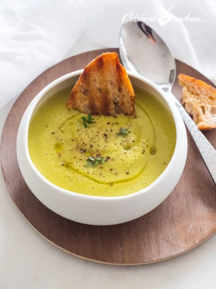 Bol de velouté de courgettes avec ail et oignon, plat savoureux et réconfortant.