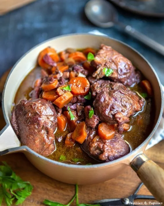 Joues de porc au vin rouge servies dans une assiette élégante