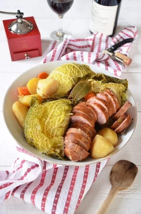 Potée chou saucisse de Morteau servie dans un plat en terre cuite