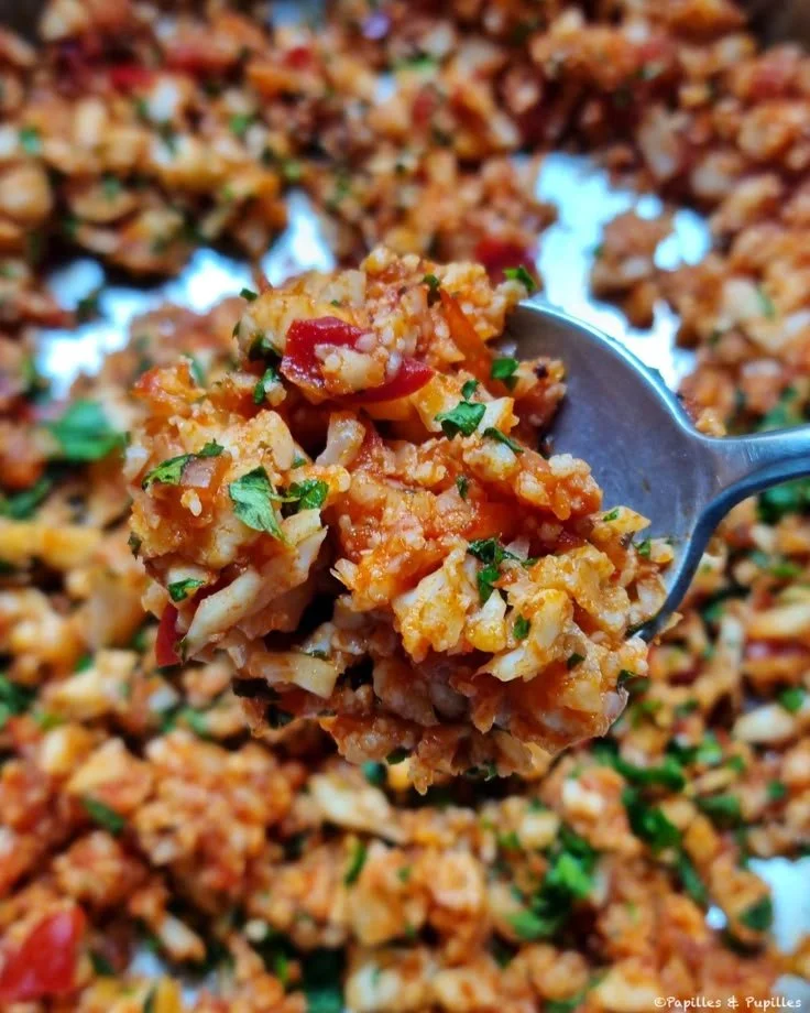 Riz de chou-fleur à la sauce tomate, cumin et citron vert dans une assiette.