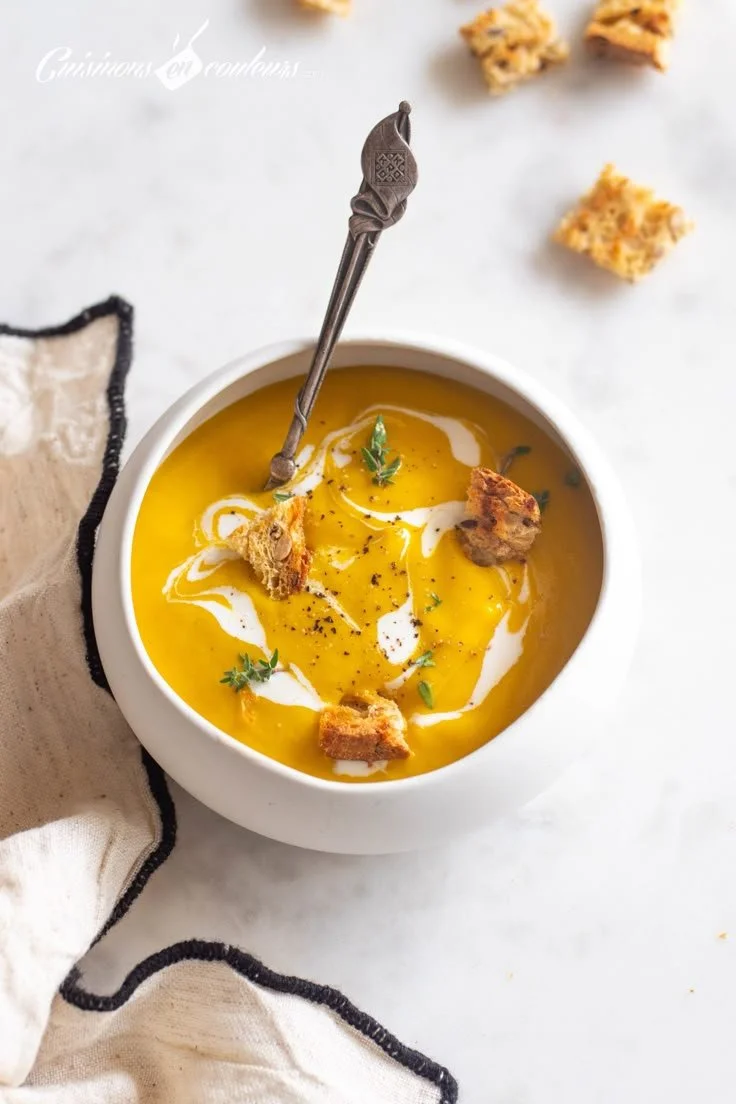 Bol de velouté de carottes et poireaux, garnie d'herbes fraîches.